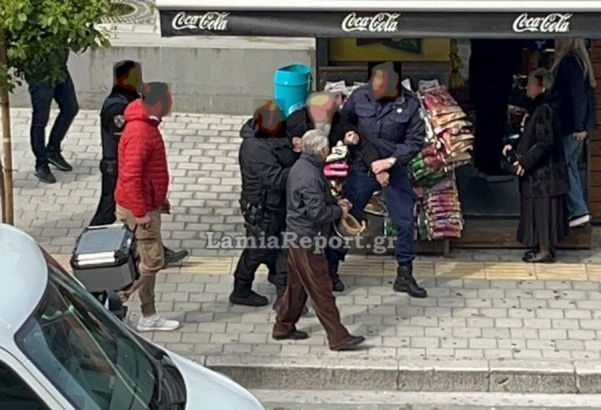 Αστυνομικοί κρατούν έναν αρχιμανδρίτη σε δρόμο της Λαμίας